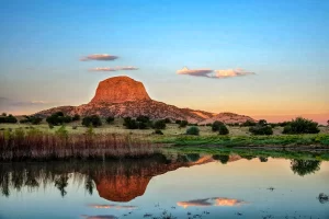 New Mexico landscape image showing a ranch pond with mountain in background