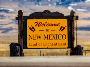 Picture of a welcome to New Mexico road sign at the border of the New Mexico and Colorado.